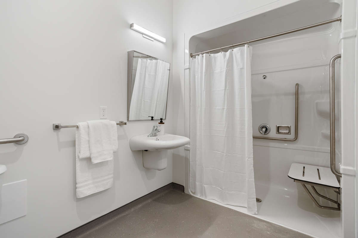 An accessible shower and sink. Photo of a one-bedroom model suite apartment at Zerin Place on South Street at 370 South St. in London Ontario. A housing project by Zerin Development in VillageSoHo.