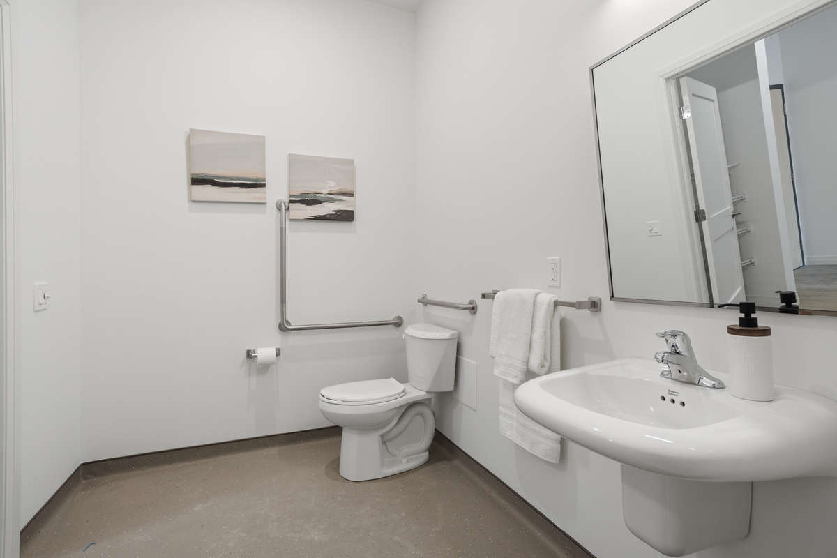 Accessible toilet and sink in an accessible bathrrom or rather shower room. Photo of a one-bedroom model suite apartment at Zerin Place on South Street at 370 South St. in London Ontario. A housing project by Zerin Development in VillageSoHo.