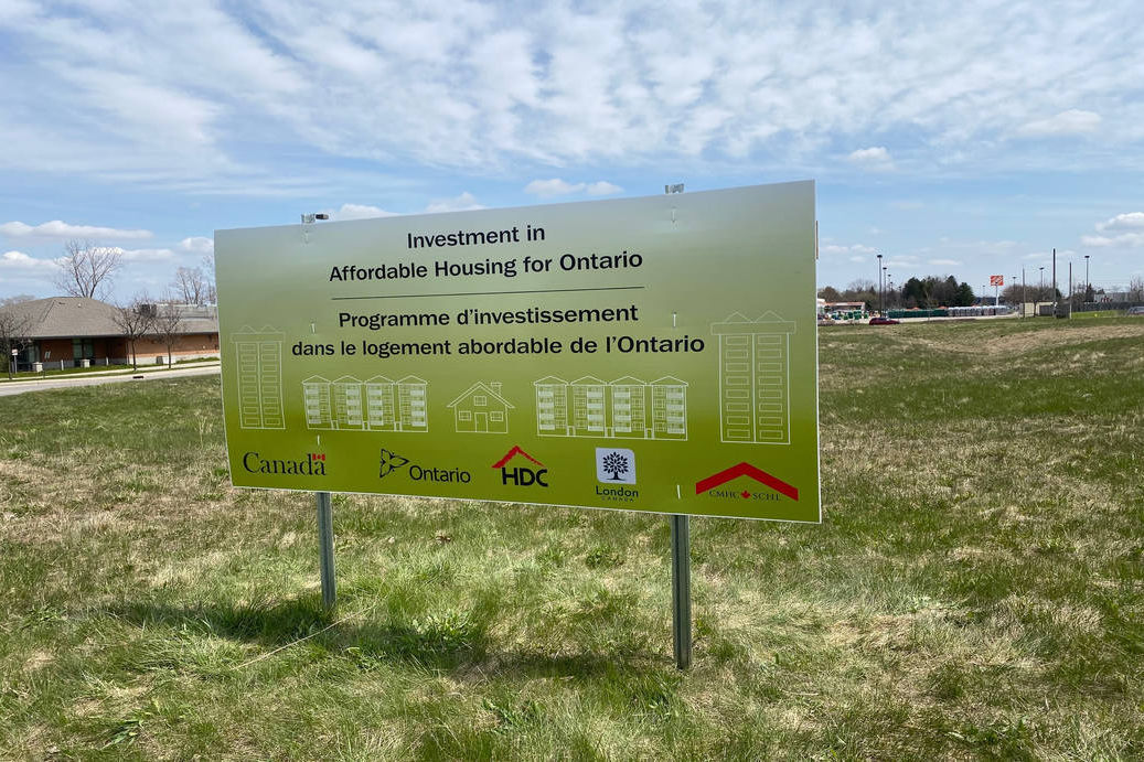 Sign at 440 Clarke Road in London Ontario listing funding partners. The sign on the site states: Investment in Affordable Housing in Ontario. Logos for the following valued funding partners are displayed: Government of Canada; Province of Ontario; Housing Development Corporation, London; the City of London; and Canada Mortgage and Housing Corporation